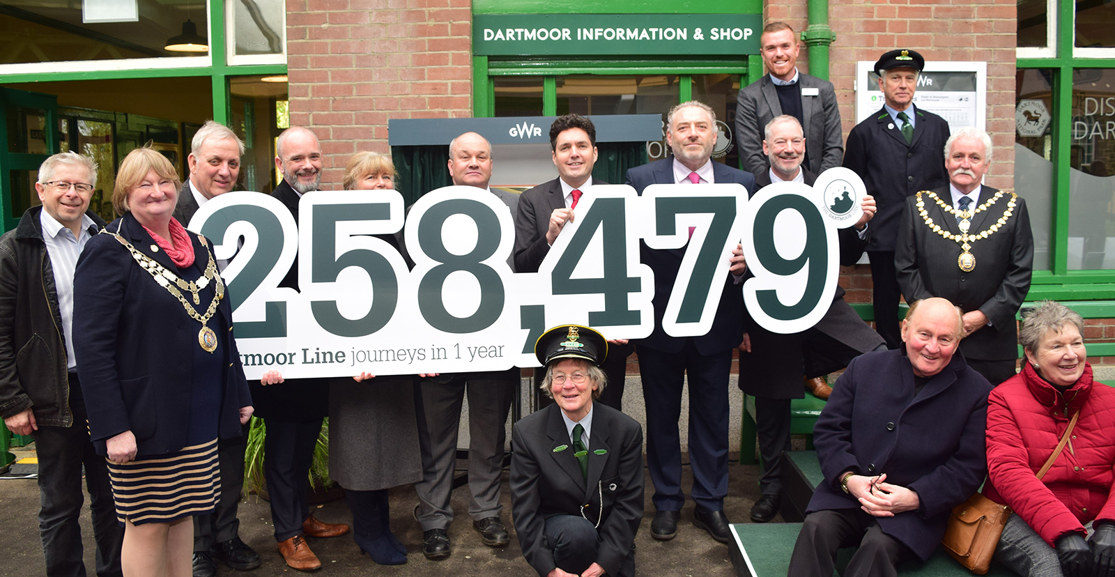 Partners hold banner saying "258,479 Dartmoor Line journeys in 1 year"